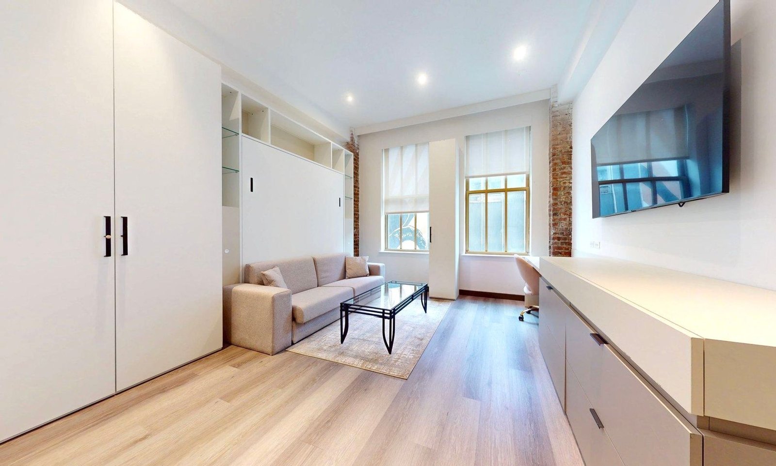 Furnished studio at 810 Gibson with sofa desk and built in cabinetry.